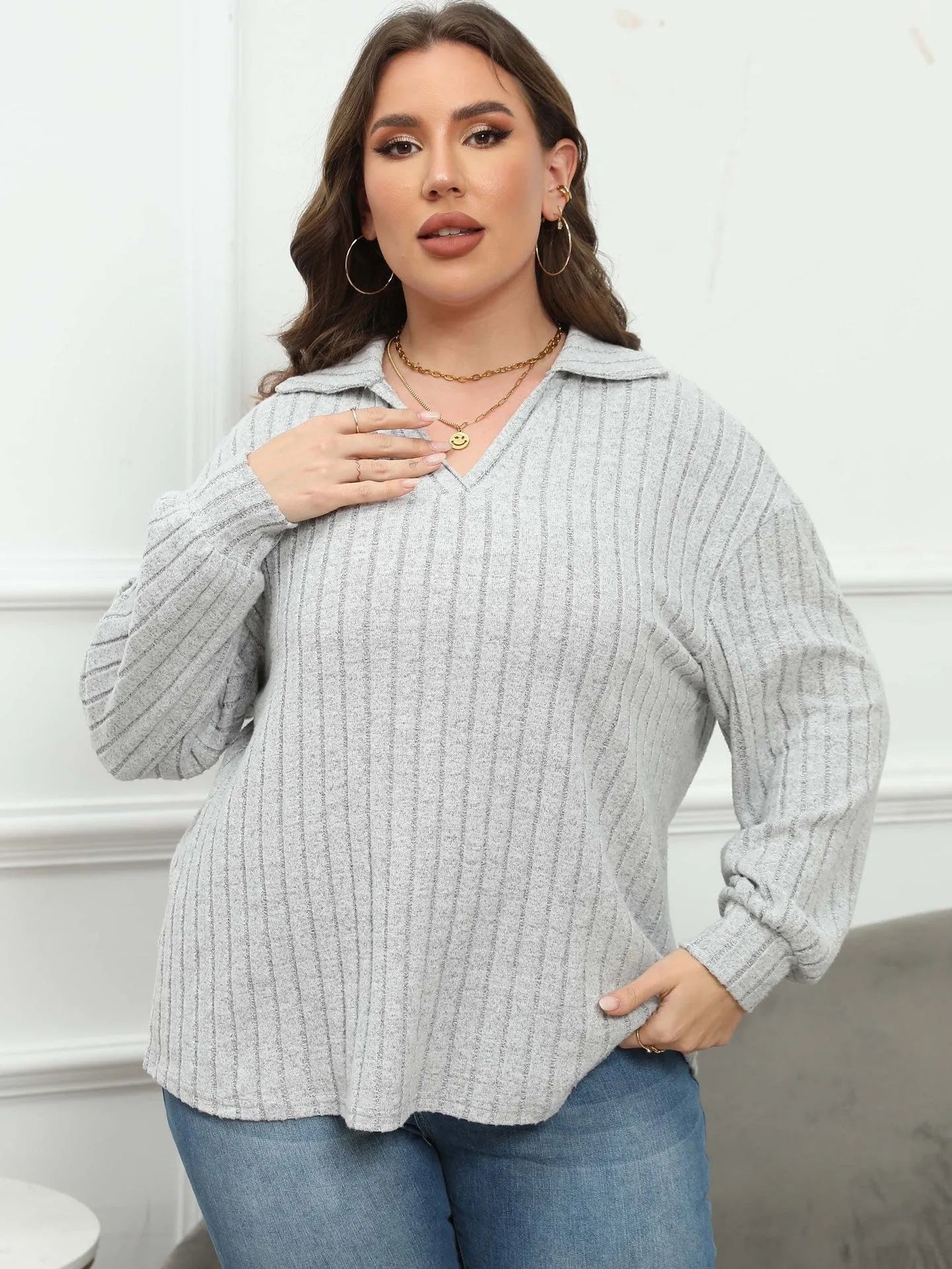 Plus size woman wearing a grey polo collar fleece pullover blouse with lantern sleeves.
