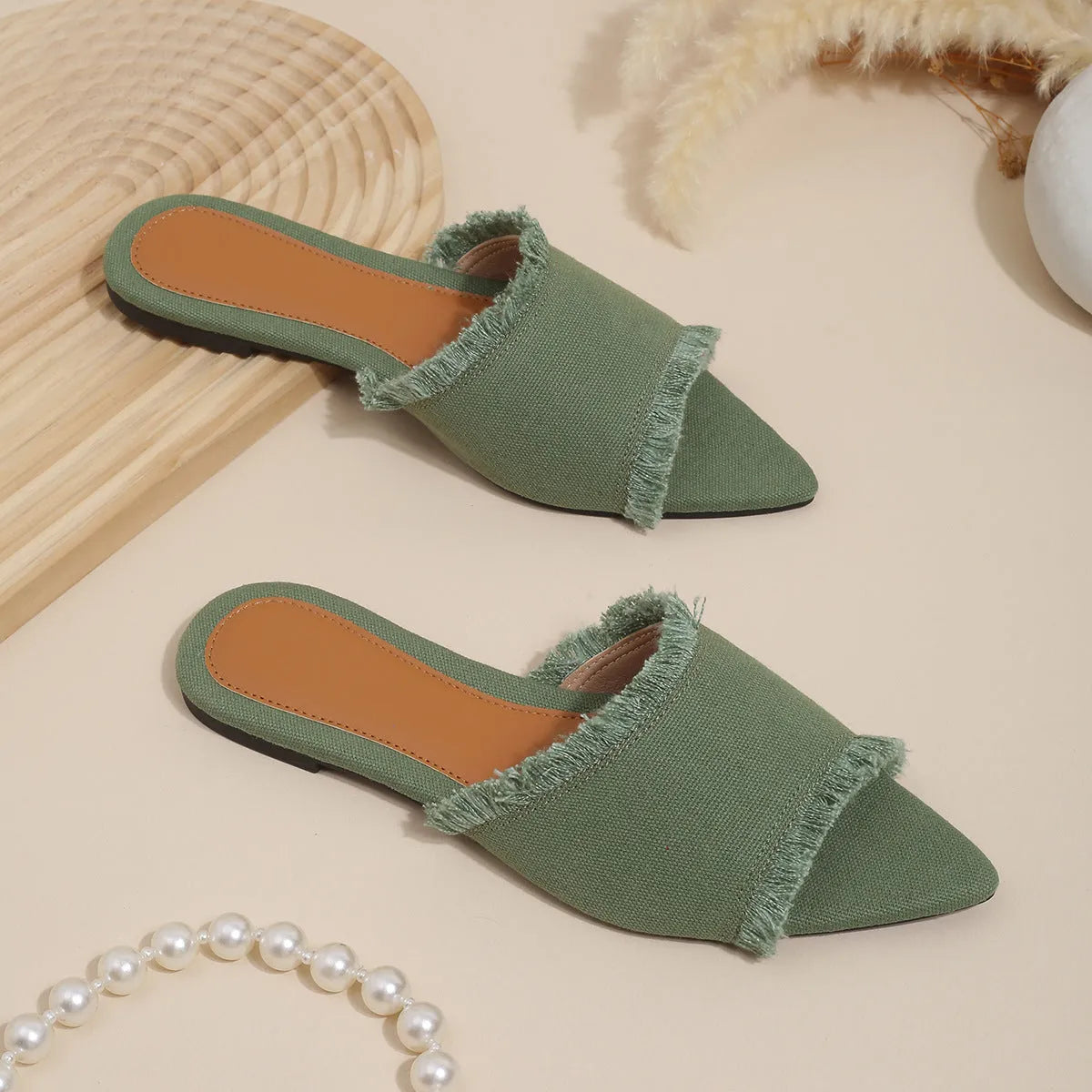 Women's denim flat slippers with a tassel, shown in available colours like apricot, black, and wine red.