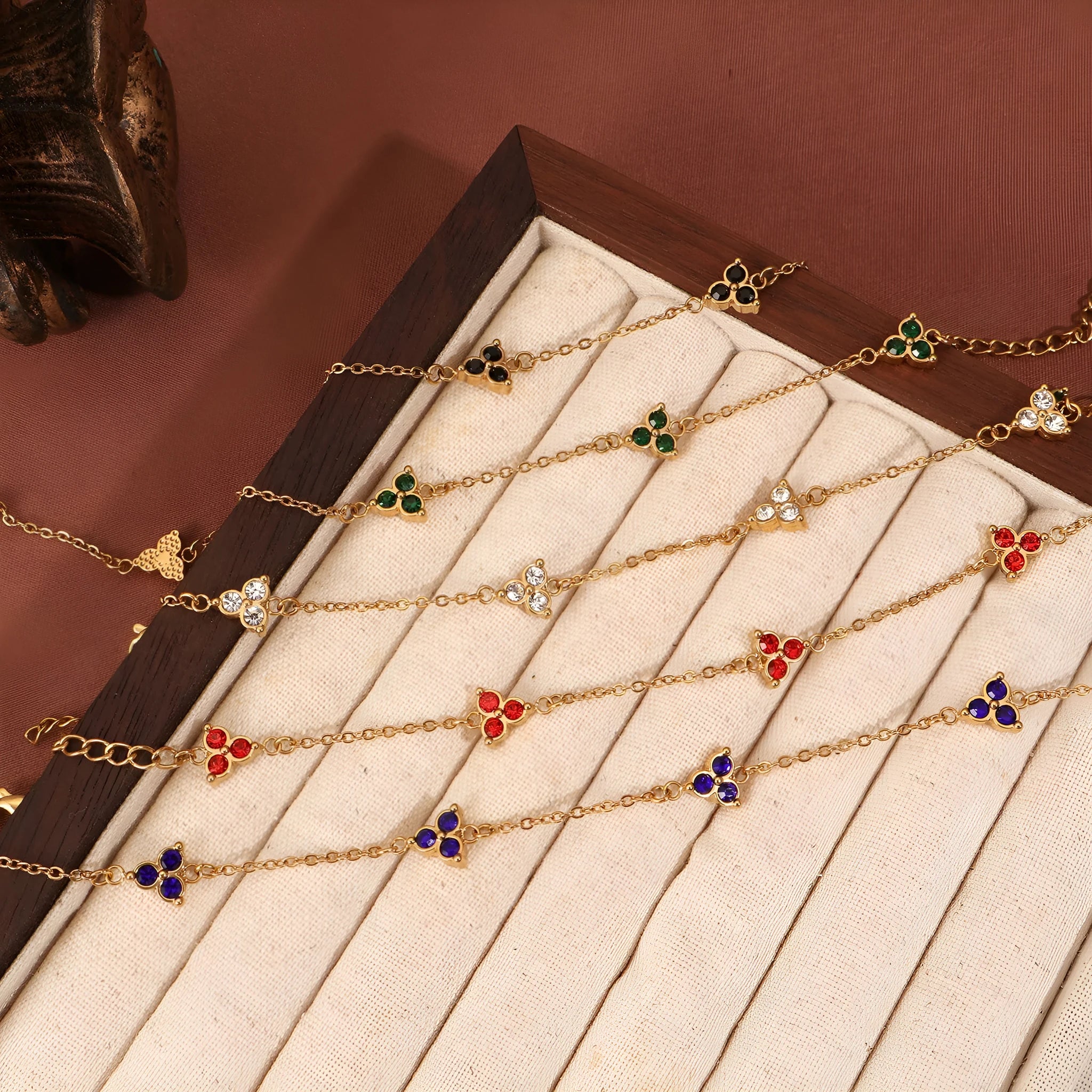 Women's stainless steel bracelet with a geometric triangle pendant, shown in gold and steel tone options with coloured stones.