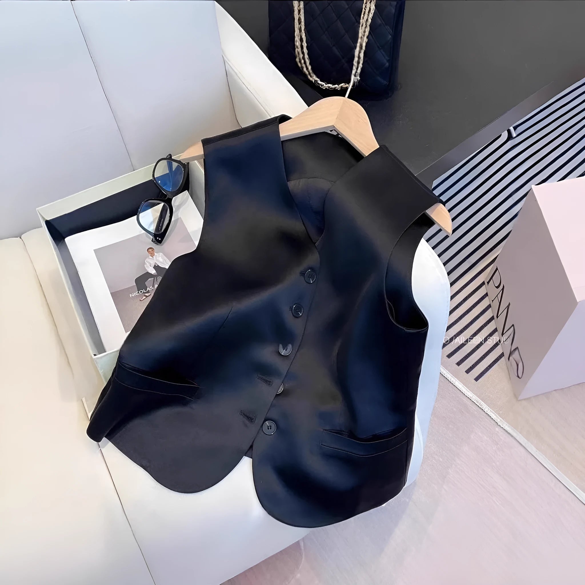 Black satin sleeveless loose-fit vest for women on a hanger