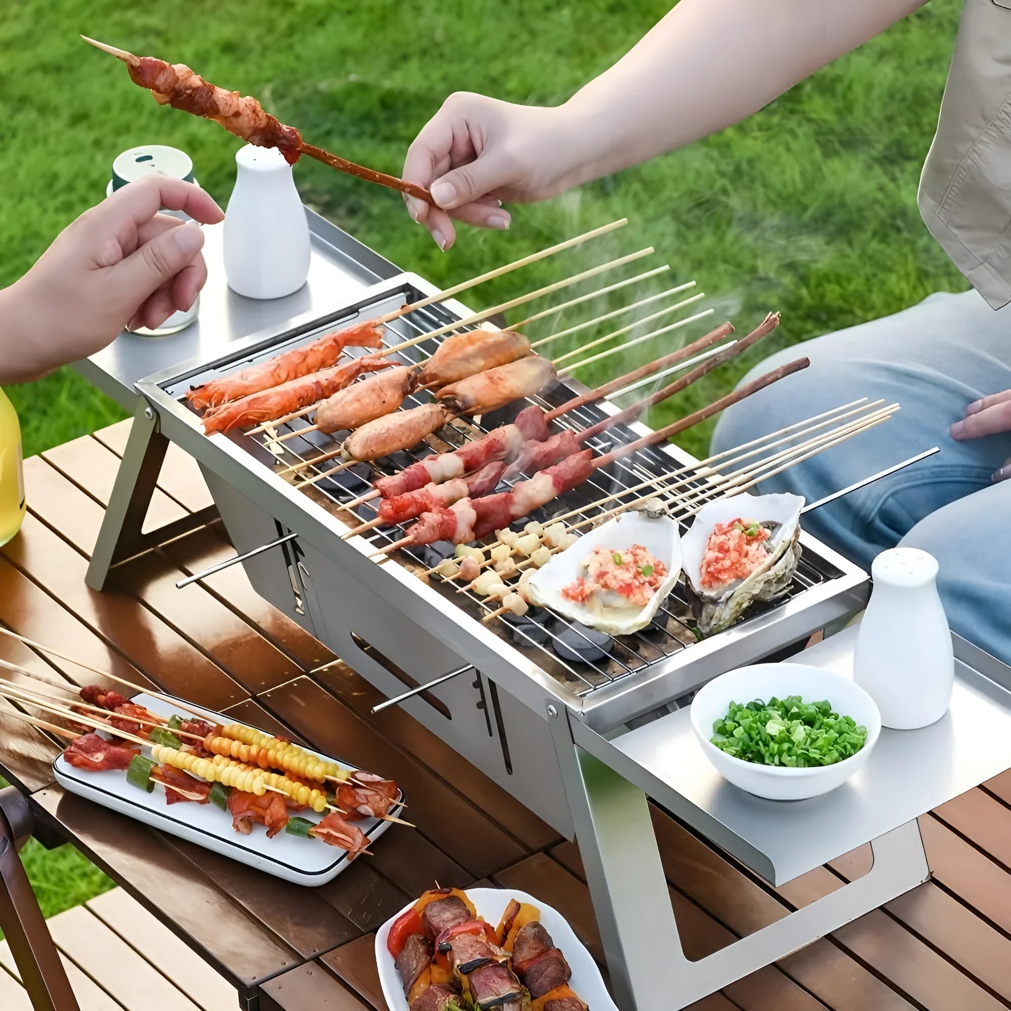 Small foldable portable charcoal grill shown in an outdoor setting.