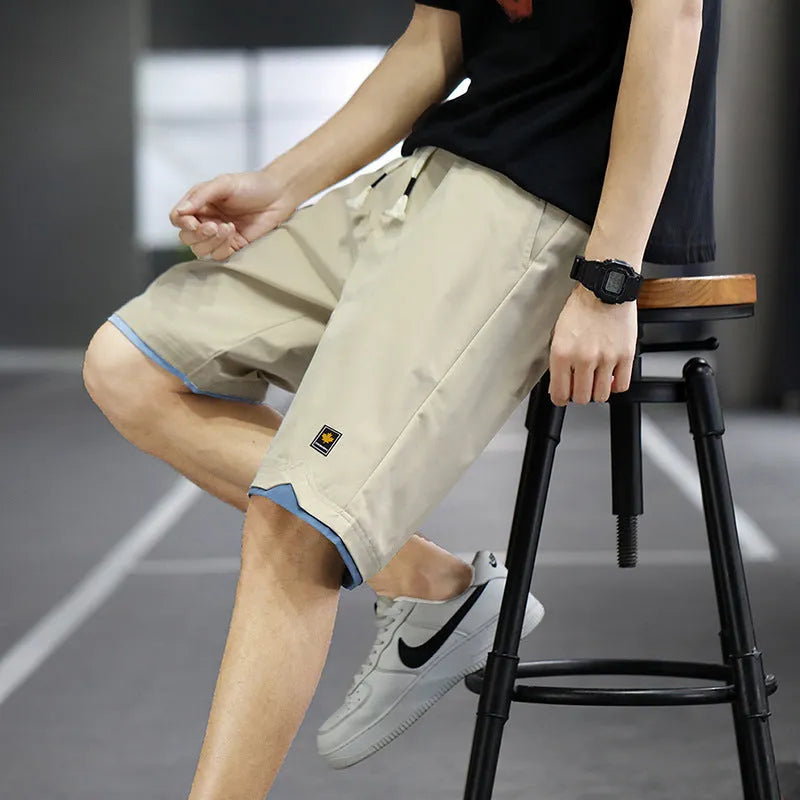 Men's straight loose fit casual beach shorts in green on a mannequin, showing elastic waistband.