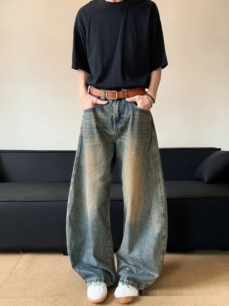 Man wearing retro blue distressed wide-leg denim jeans with a mid waist and zipper fly.