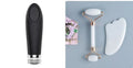 White jade double-headed facial roller and scraping board set on a plain surface.