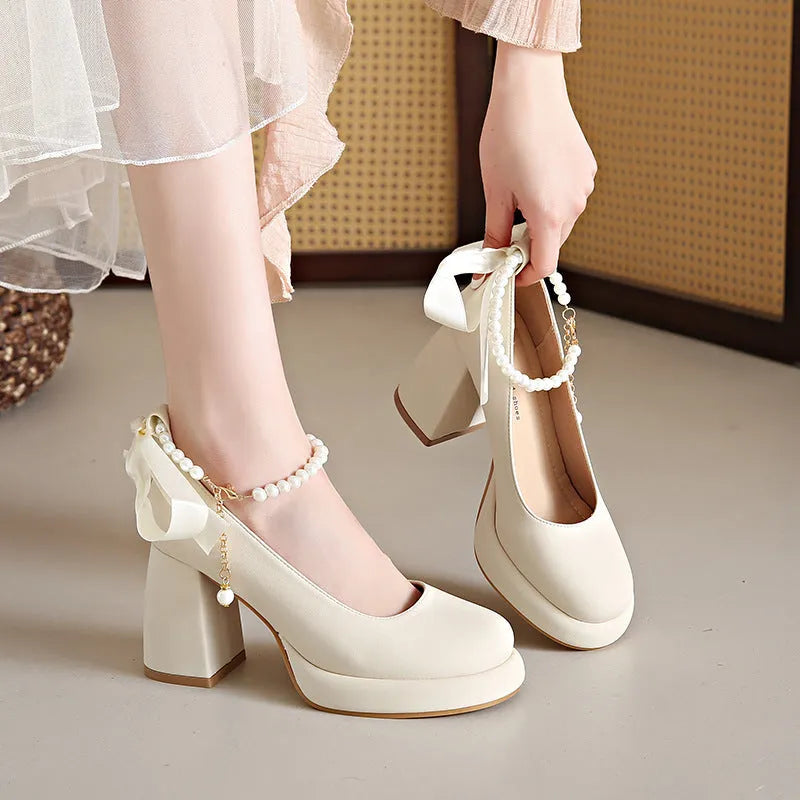 Women's beige Mary Jane shoes with chunky heel and ankle-strap buckle on a white background