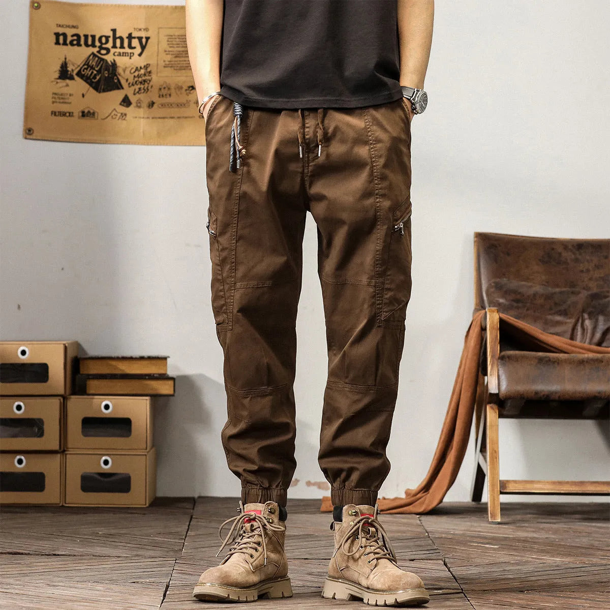 Men's khaki cotton tapered harem pants with ankle bands and a zip fly, laid flat.