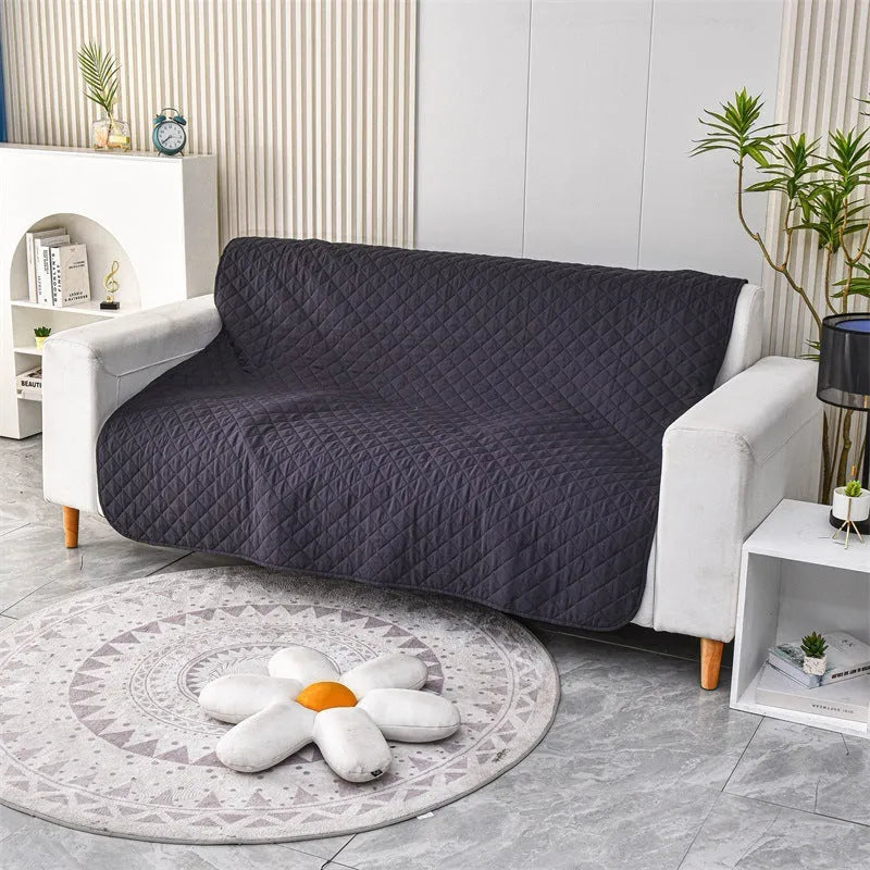 Reversible dog blanket showing two colours, laid flat on a sofa as a protective cover