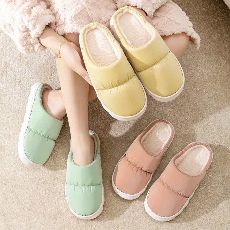 Pair of down cotton indoor slippers with artificial leather upper and thick rubber sole.