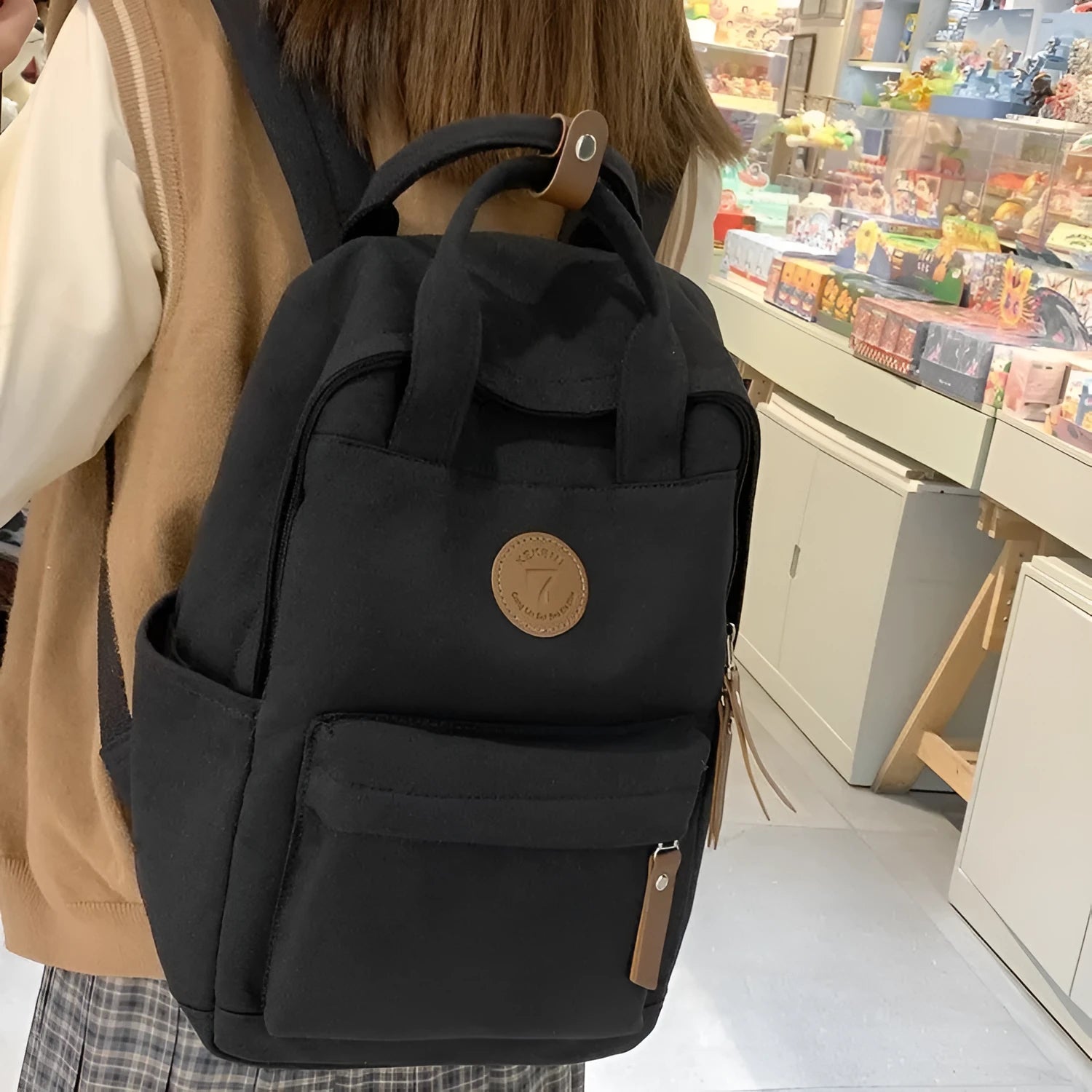 Black Oxford cloth backpack with curved shoulder straps and retro sewing thread accents