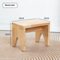 Solid wood distressed finish shoe changing stool with bracket legs in a living room setting.