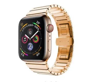 Silver metal Apple Watch strap with butterfly buckle on a wrist, showing the clasp closed.