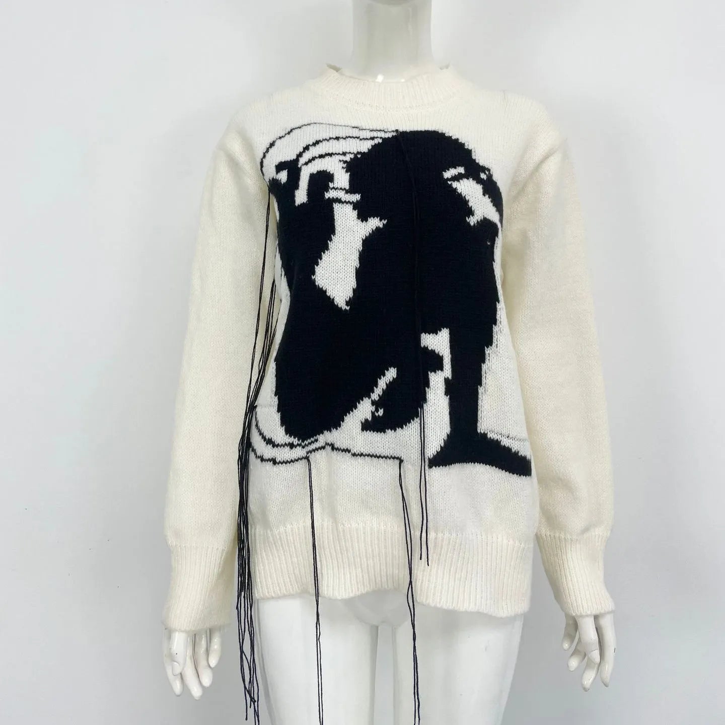 Grey women's loose alpaca wool sweater with a round neck, regular sleeves, and a long tassel detail.