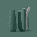 Ultra-light six-fold sun umbrella open, showing NC fabric canopy and rubber handle, next to its compact folded size in a capsule box.