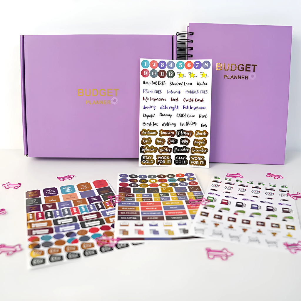 Purple coil-bound budget notebook with daolin paper pages, pen, stickers, and paper clips for financial planning