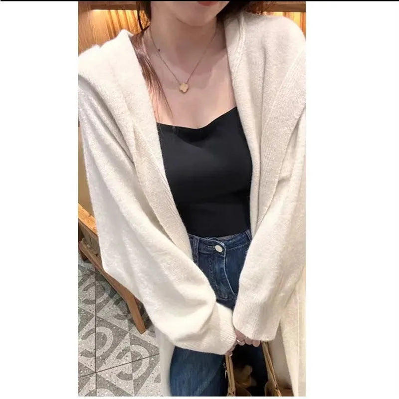 Long grey hooded knitted cardigan on a hanger showing its below-the-knee length and loose fit.