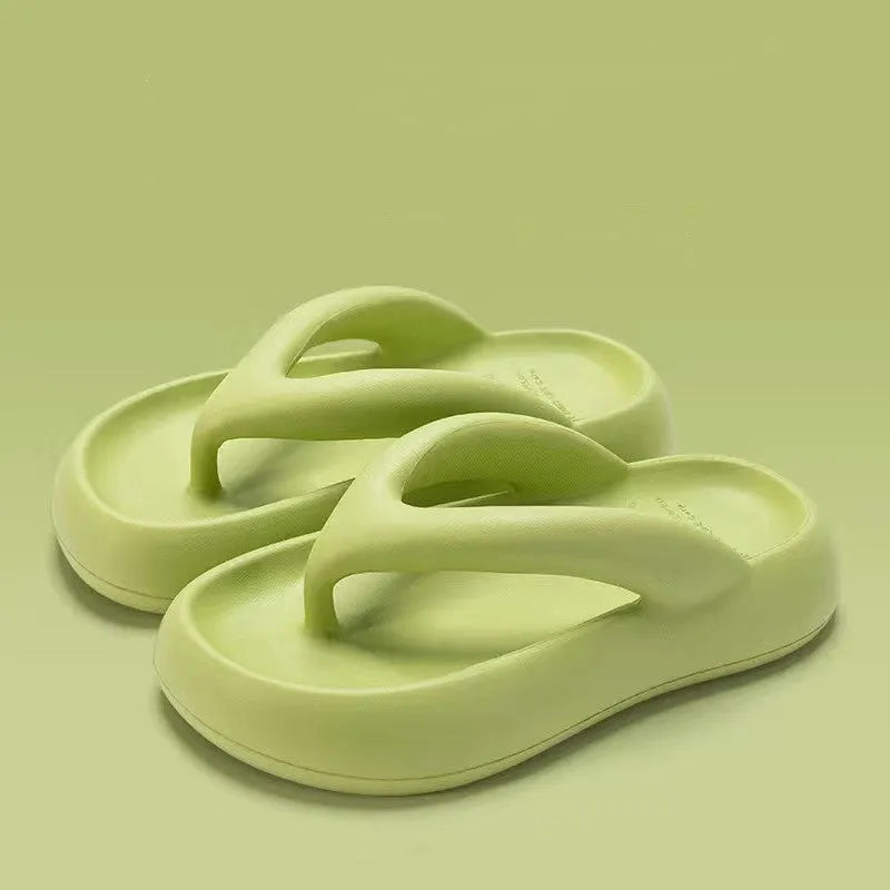 A pair of thick-soled flip-flops with a bow detail on the upper, shown in a solid colour.