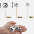 Glass disco ball cake decorations with wooden sticks in multiple sizes on birthday cake
