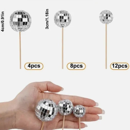 Glass disco ball cake decorations with wooden sticks in multiple sizes on birthday cake