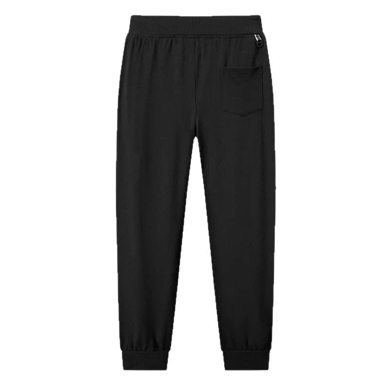 Men's thin leisure tapered knitted pants in black with ankle tie, standing on a neutral background