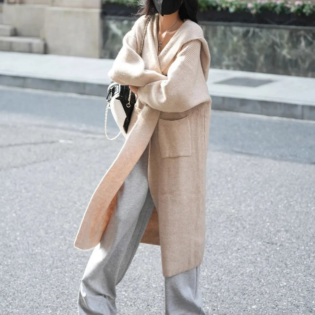 Women's long grey knitted cardigan hooded trench coat on a hanger.