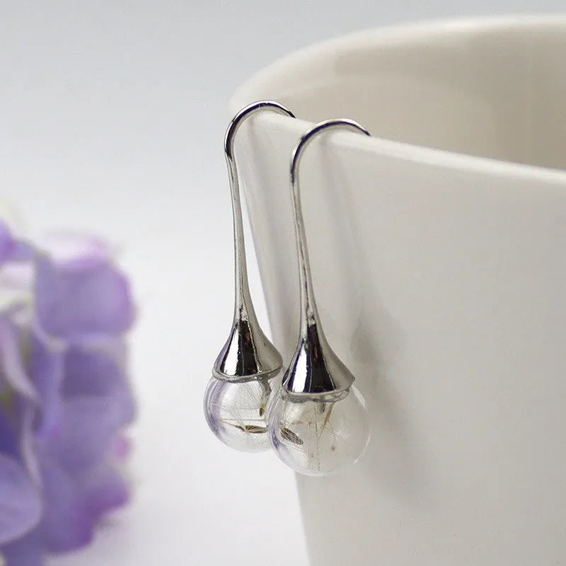 Transparent glass ball earrings with dandelion seed design on silver French hooks