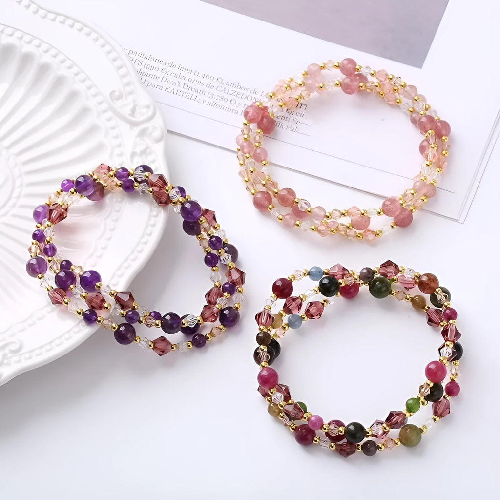 Close-up of a women's hand-made three-ring crystal bracelet with colourful beads on an adjustable rope.