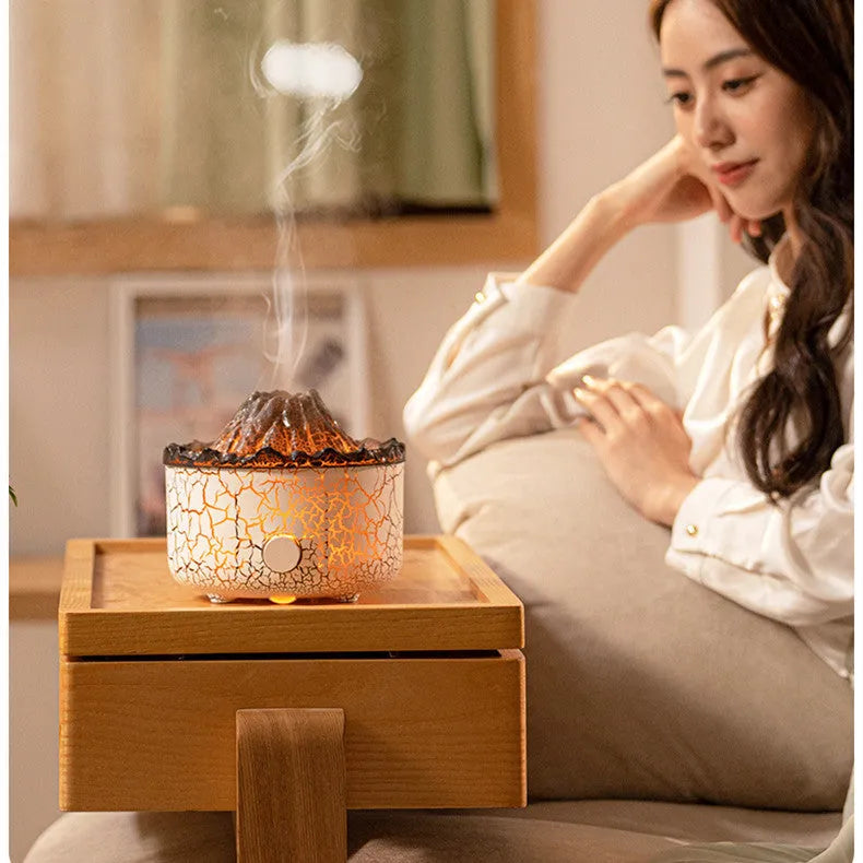 Volcano humidifier with LED lights and mist creating a fiery flame effect, column-shaped plastic body on a table
