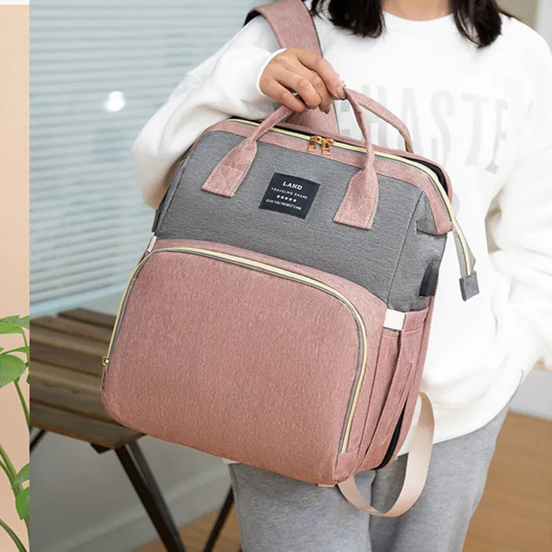 Large capacity insulated baby crib backpack in pink grey with double shoulder straps and outer pocket on white background