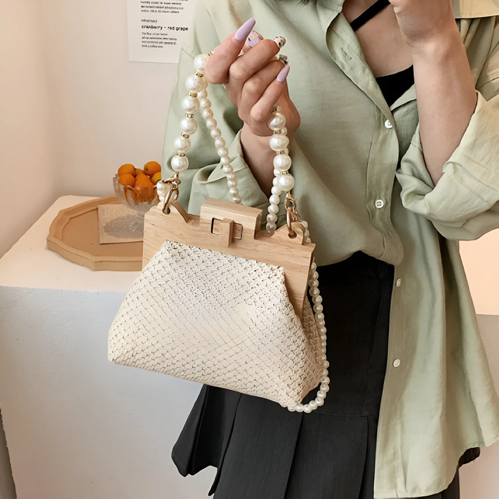 Women's woven straw shoulder bag with pearl chain strap showing interior organiser compartments