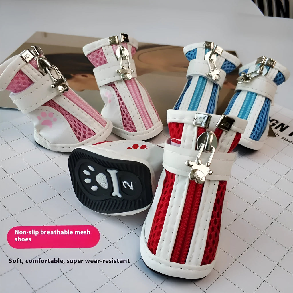 Four blue cloth dog shoes with zipper closures, showing non-slip soles, laid out on a white surface.