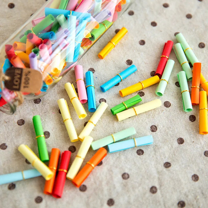 Multi-coloured mini paper scrolls with metal eyelets in 3x7cm, 4x7cm, 5x5cm, and 7x7cm sizes for drift bottle messages