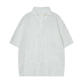 Men's loose-fitting black hollow knit short-sleeved polo shirt on a hanger, casual style.