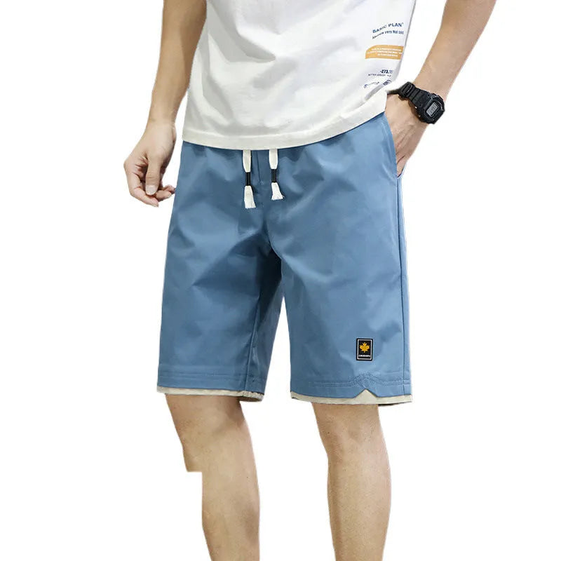 Men's straight loose fit casual beach shorts in green on a mannequin, showing elastic waistband.