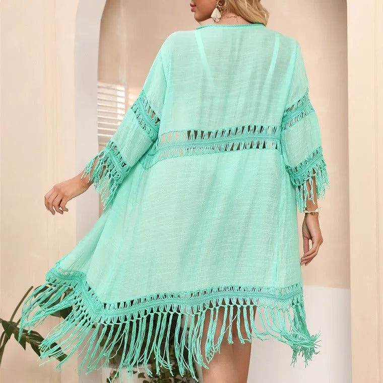 Yellow hand-crocheted acrylic cardigan with tassel details, laid flat as a women's beach cover-up.