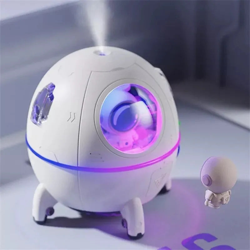 Purple astronaut-shaped USB desktop humidifier with LED light on wooden desk