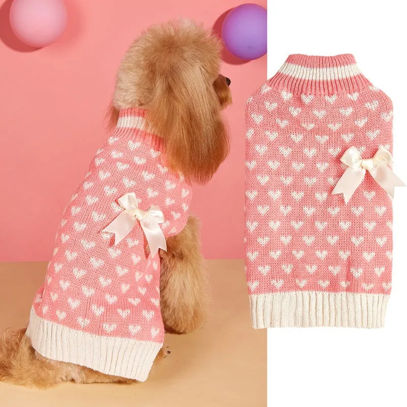 Red and pink dog sweater with love heart and bow design on a small dog.