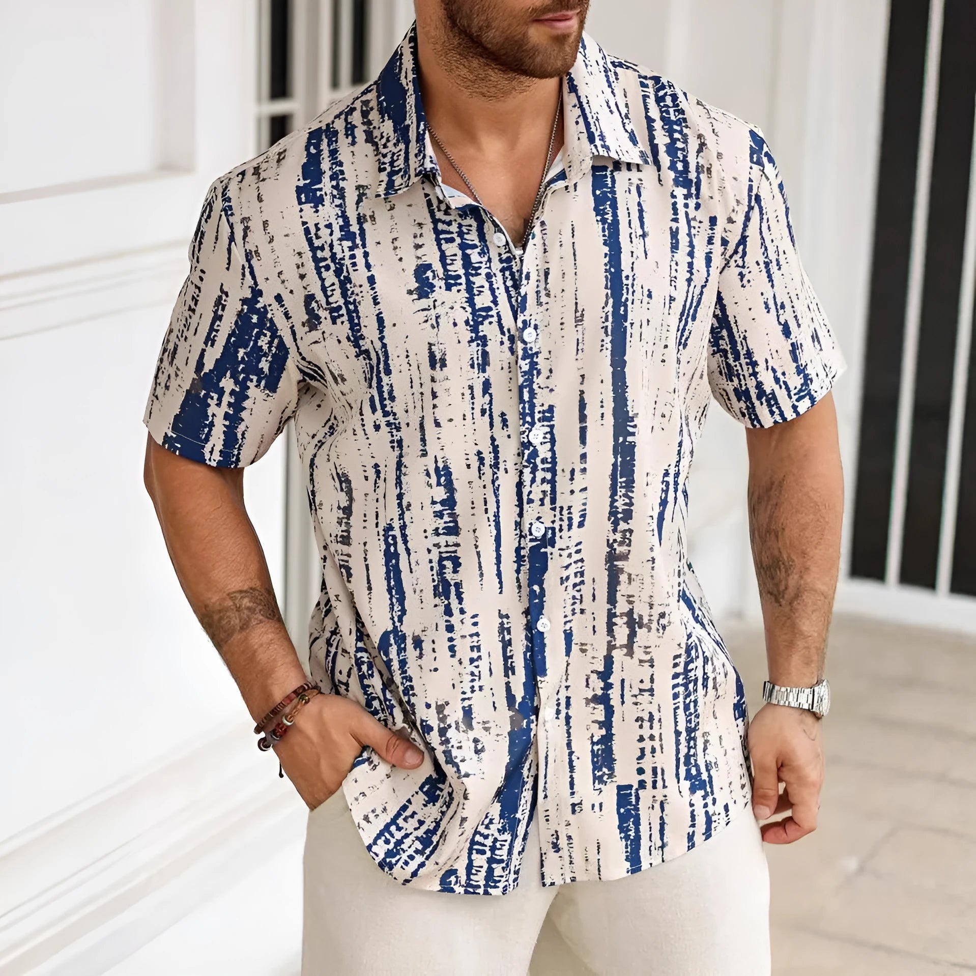 Man wearing a short sleeve striped casual shirt in a blue colour with a 3D printed pattern.