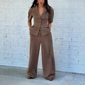 Brown men's slim fit polyester suit with long sleeve top and trousers on a hanger.
