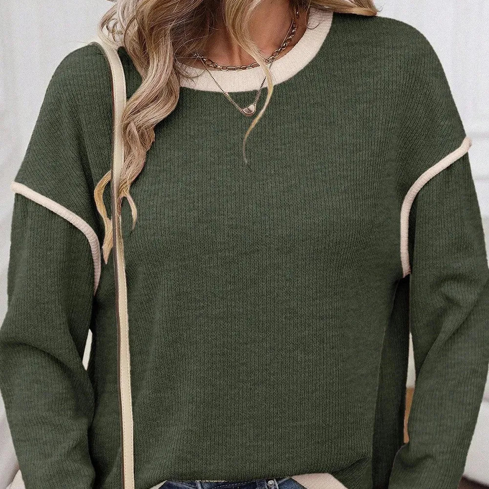 Woman wearing a green four leaf clover pattern loose knit top with drop shoulders and contrast trim