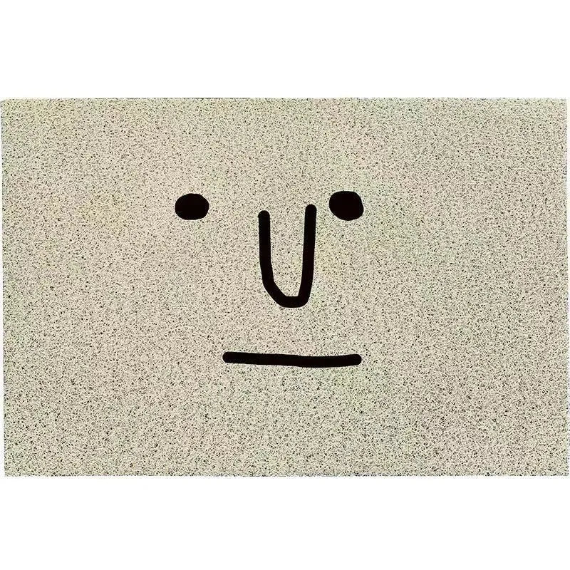 Square PVC floor mat with a cartoon face and geometric pattern in Mr. Big Nose colour.