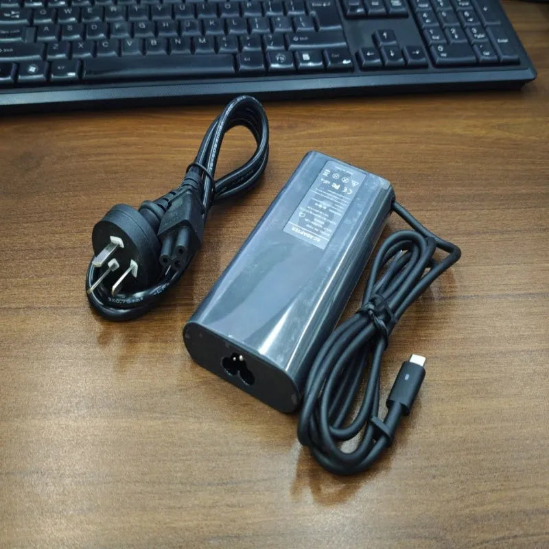 Black 65W Type-C laptop power adapter with a set of interchangeable international plug heads.