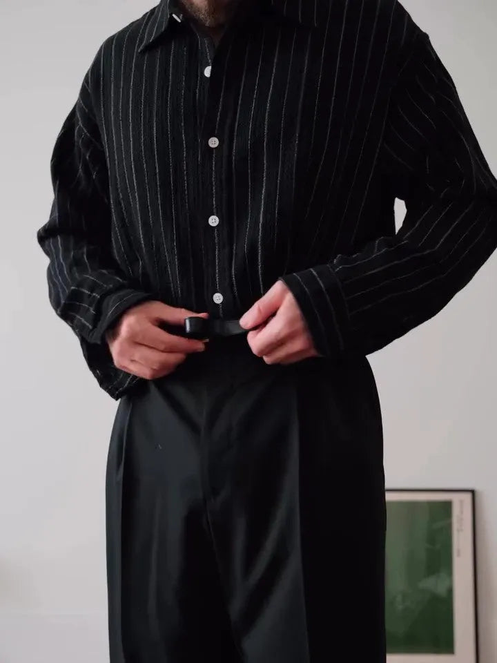 Black and white pinstriped long sleeve button-down shirt on a hanger.
