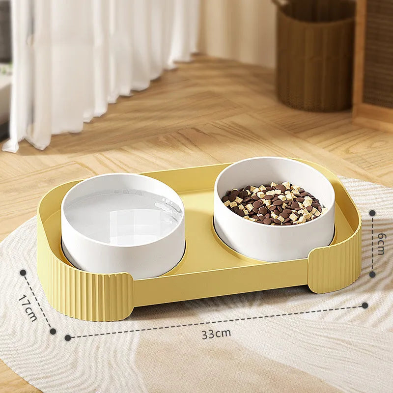 Green ceramic raised cat food and water bowls set with tilted stand on a kitchen floor.