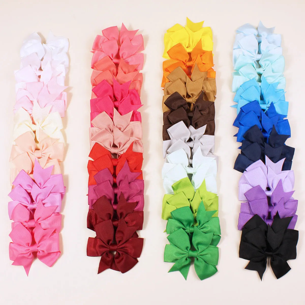 Assortment of handmade 3-inch grosgrain ribbon pinwheel hair bows with alligator clips for toddler girls in multiple colours.