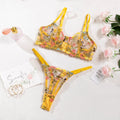 Women's floral print polyester bikini lingerie set on a hanger, showing colour options of skin, purple, black, yellow, and pink.