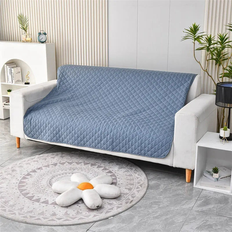 Reversible dog blanket showing two colours, laid flat on a sofa as a protective cover