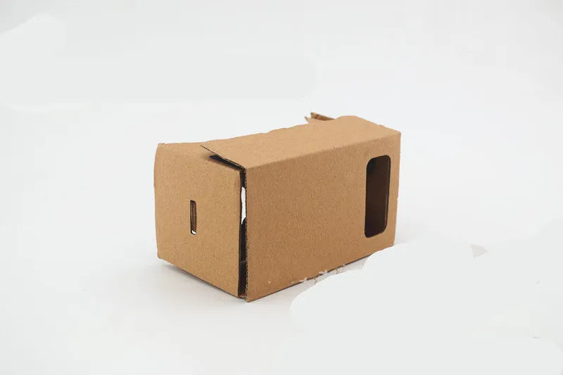 Foldable pink and white cardboard VR headset for smartphones with lenses and a head strap.
