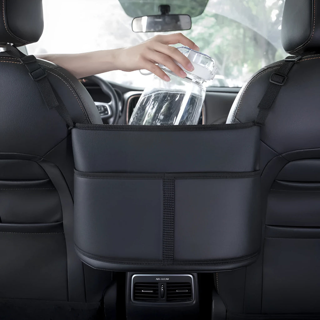 Black leather car seat storage bag with a carbon fibre pattern, shown mounted between car seats.