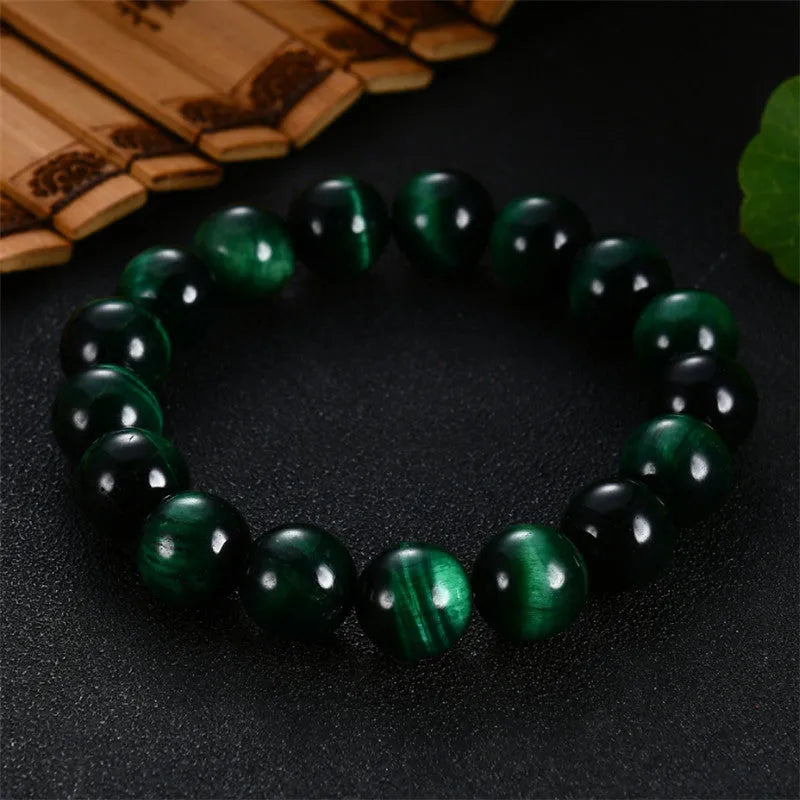 Green tiger eye stone geometric bead bracelet with adjustable closure on a wrist.