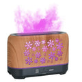 Colourful snowflake pattern aromatherapy humidifier with glowing flame effect and remote control on a desktop.